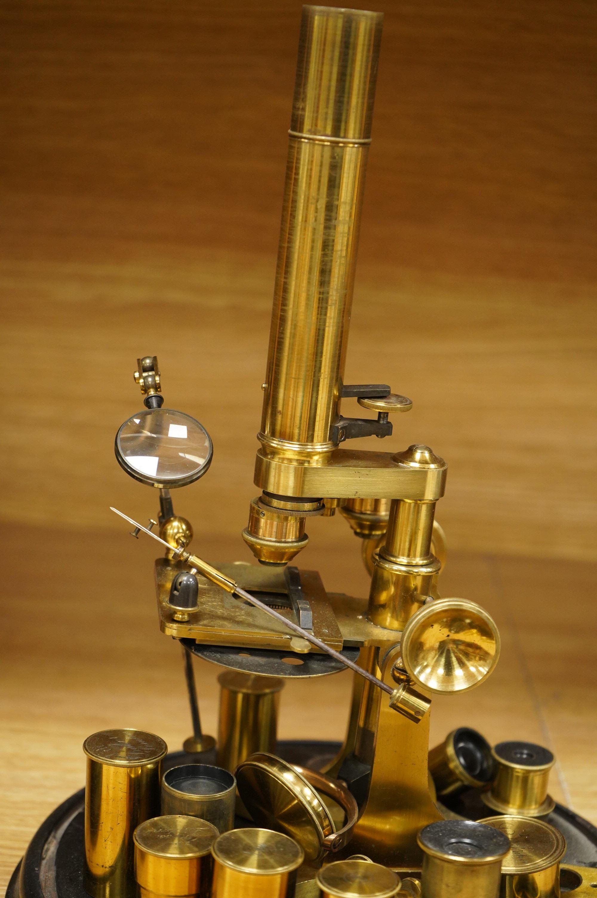 A mid 19th century brass monocular microscope, unsigned, with five objectives and three eyepieces, together with a Lieberkühn, a dark spot substage condenser, and a pair of Nicols prisms